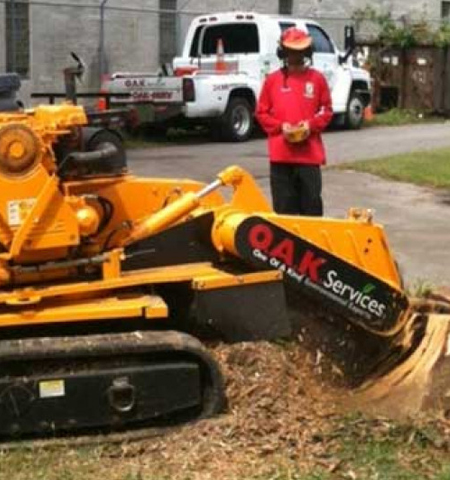 OAK Services professional operating tracked equipment for stump grinding and debris removal at a residential property in Aiken, SC